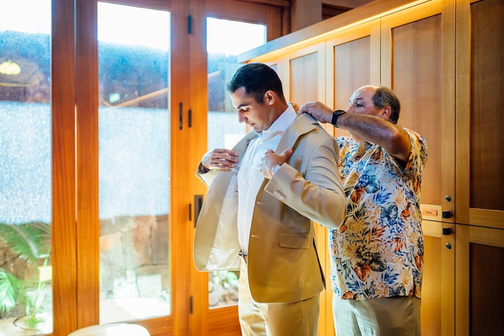 groom with his dad putting his coat on 