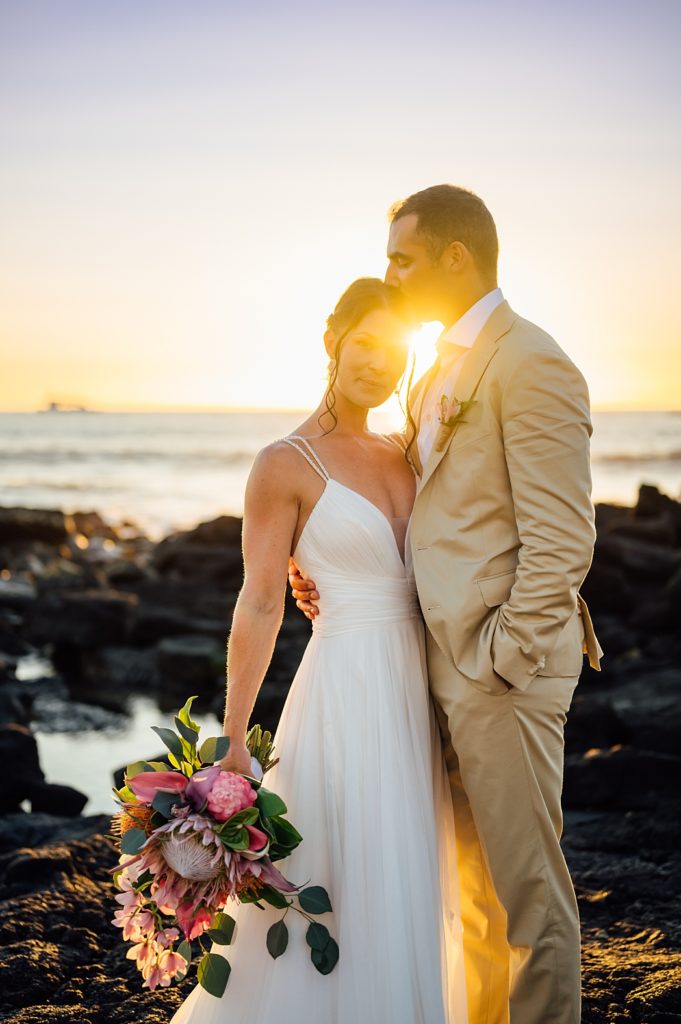 newlyweds under the stunning sunset by Big Island wedding photographer
