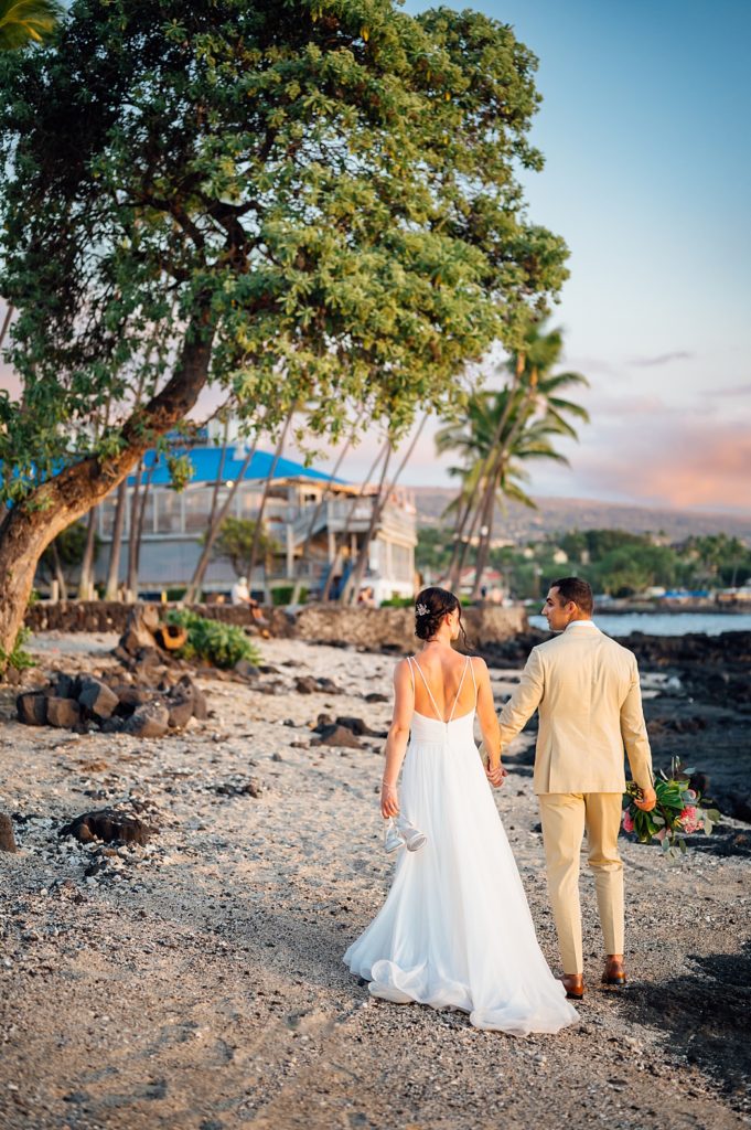 bride and groom walking on a beach at the Big Island