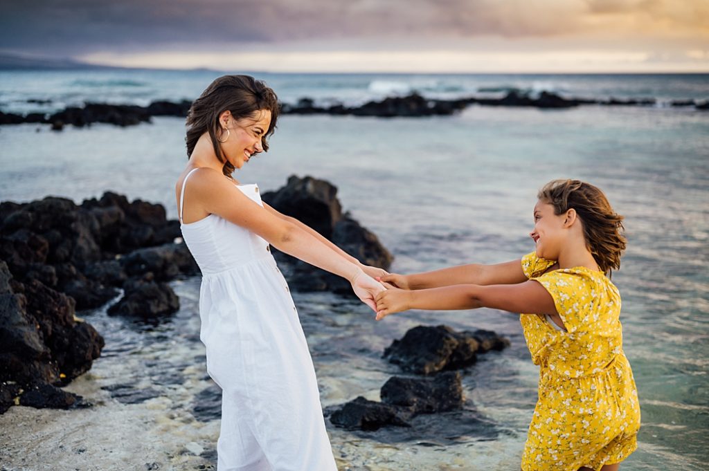sisters holding hands at a beach in the Big Island