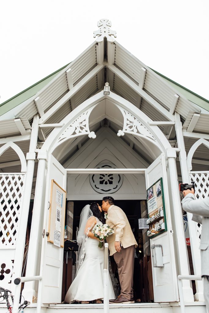 newlyweds kiss at the Painted Church on the Big Island