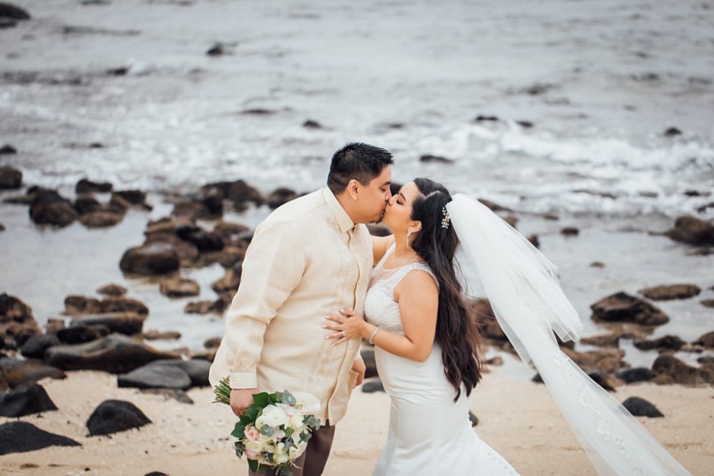 bride and groom kissing at a beach on the Big Island