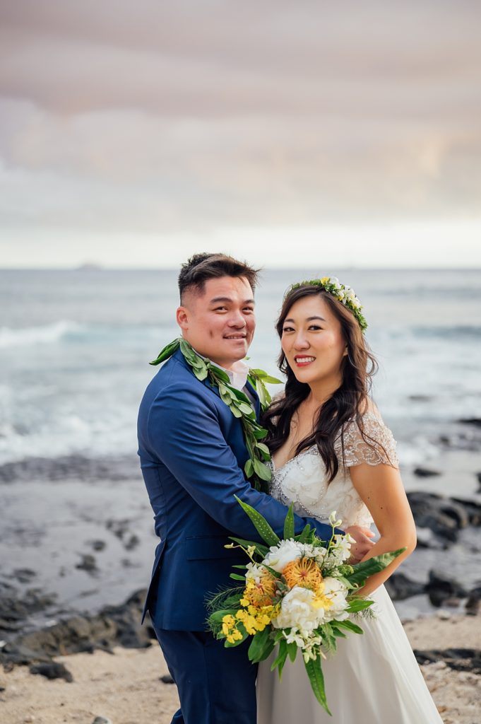 bride and groom embracing at Hawaii beach