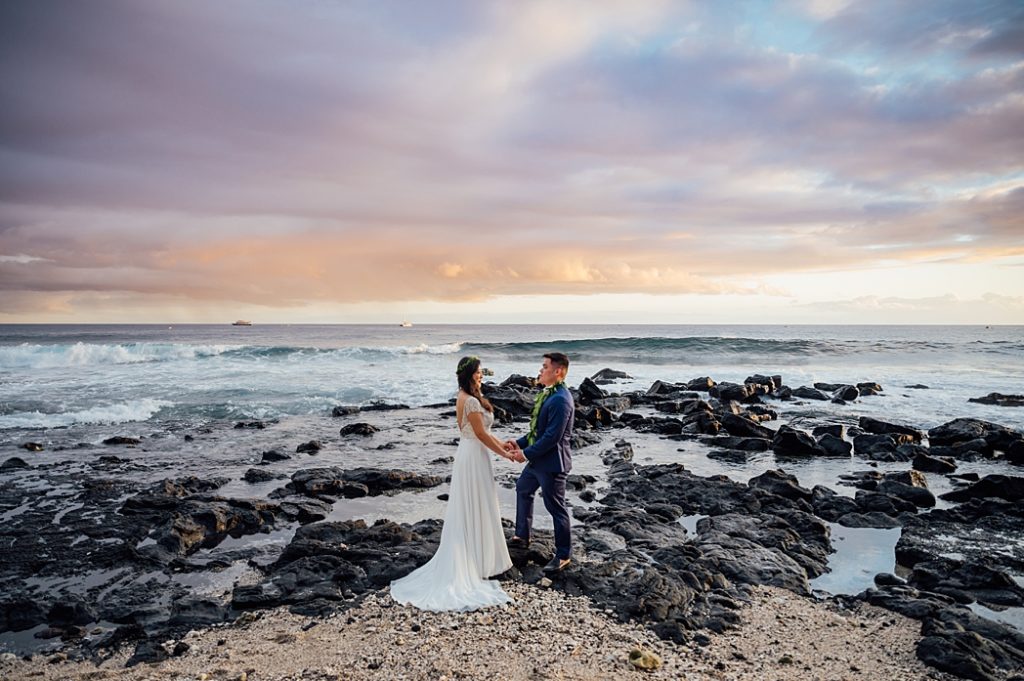 bride and groom holding hands on the lava rocks 