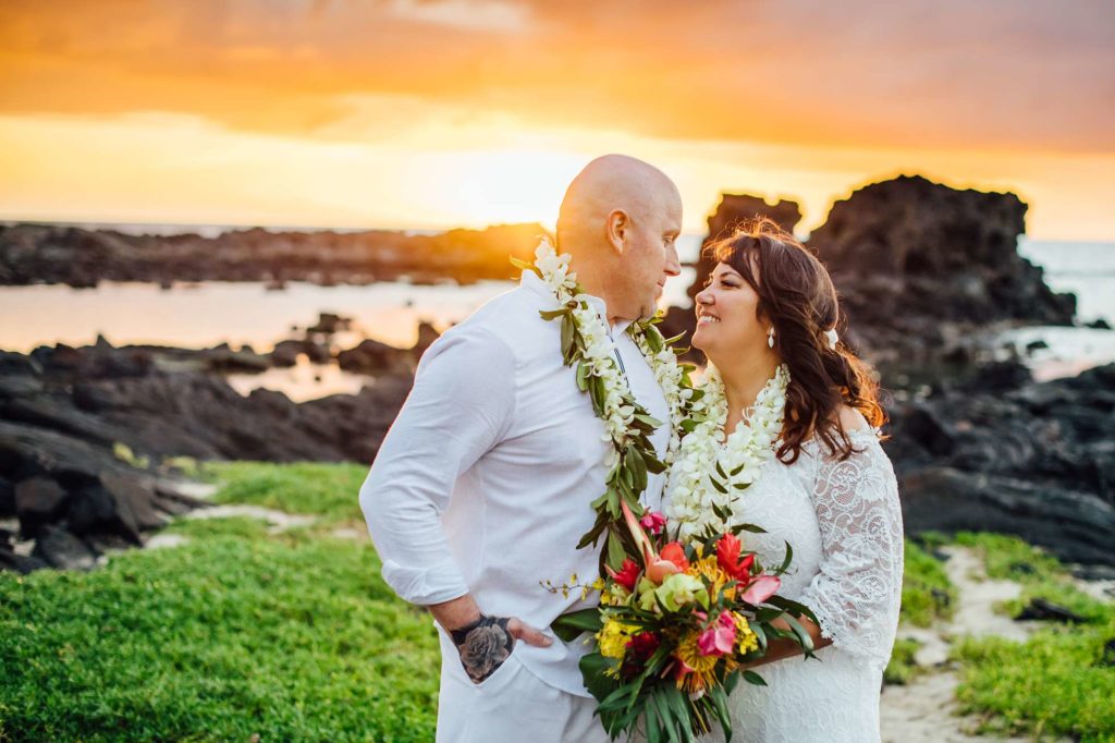 bride and groom under the stunning Hawaii beach sunset 