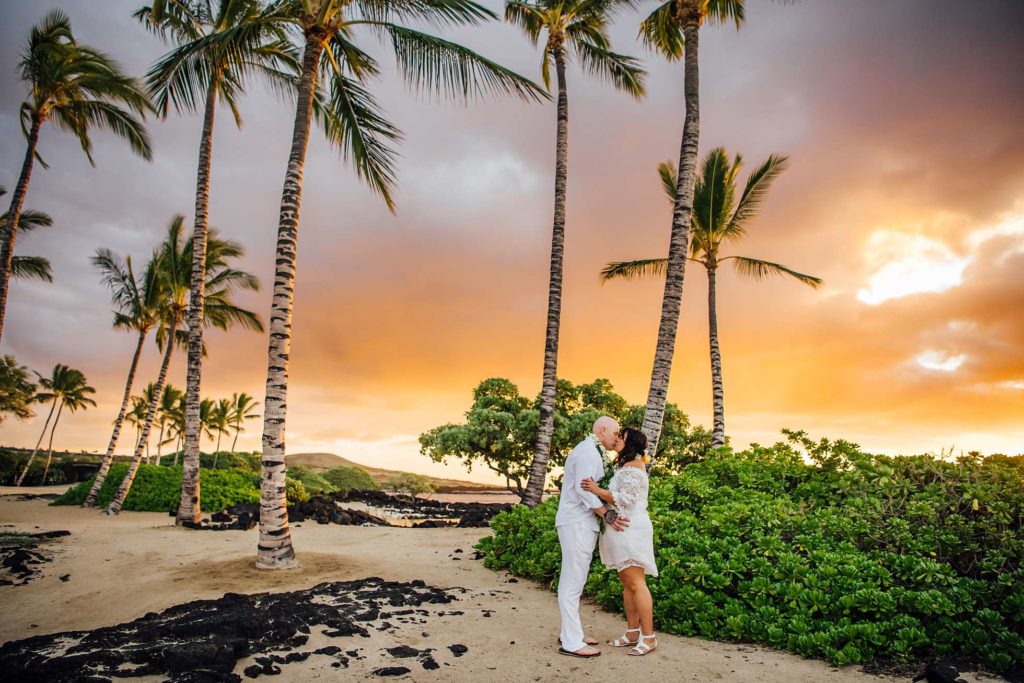 bride and groom kissing under the stunning Hawaii sunset 