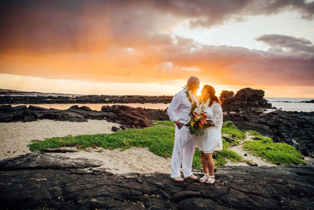 bride and groom standing on the Hawaii lava rocks