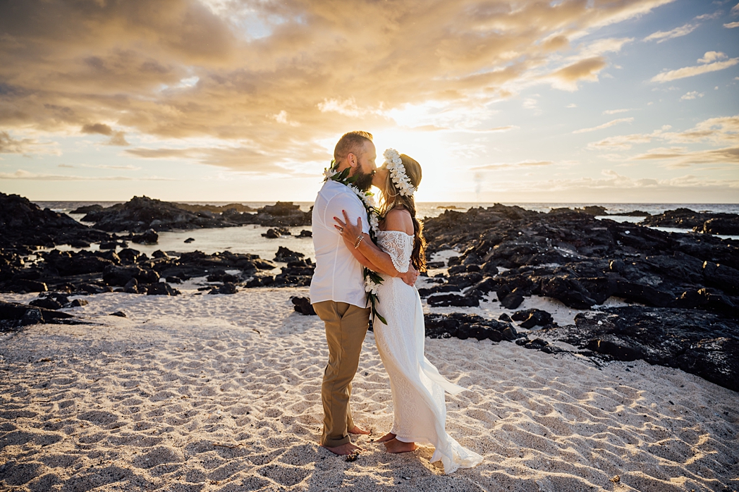 bride and groom kissing on the beach during their elopement
