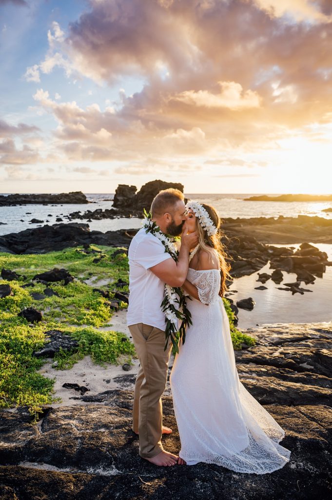 bride and groom kiss under the Hawaii golden sunset