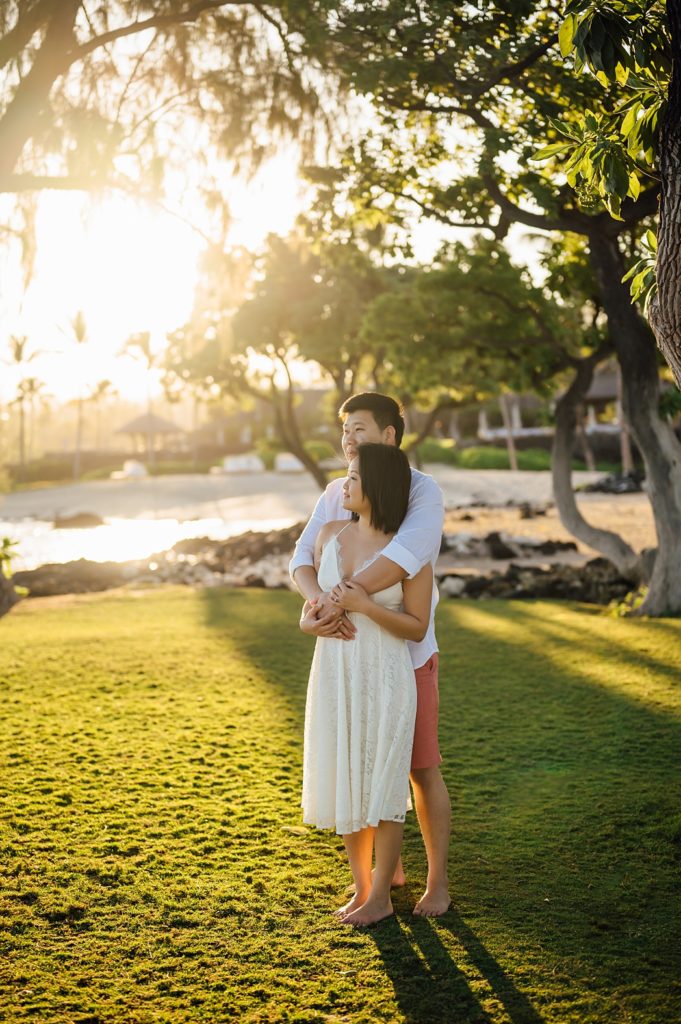 couple snuggling under the Hawaii golden sunset