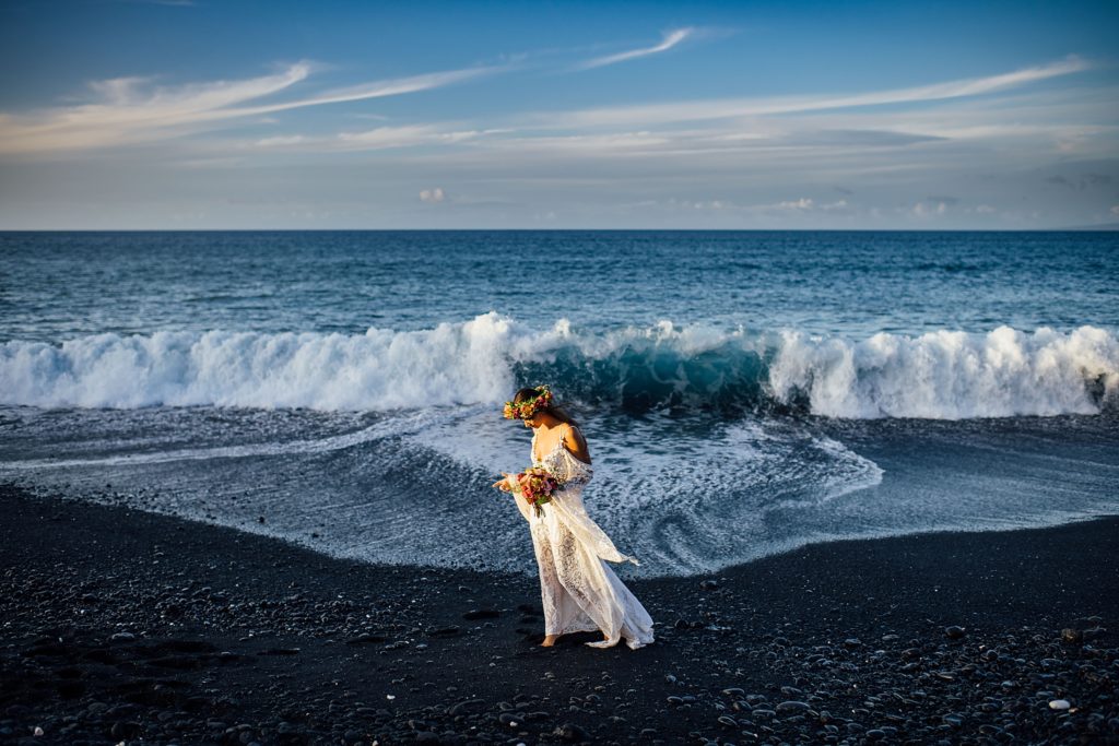 big waves behind the bride on the black sand beach