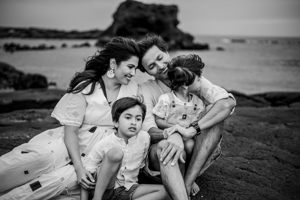 happy family sitting on the lava rocks during their photoshoot