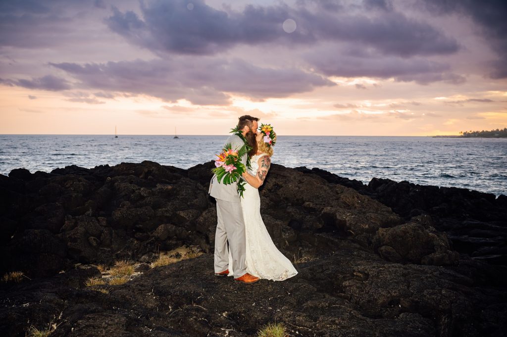 bride and groom kissing on the lava rocks in Kona