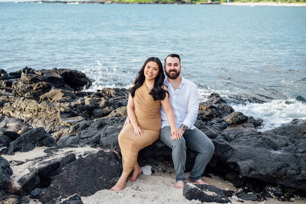 engagement photo of couple sitting on the lava rocks