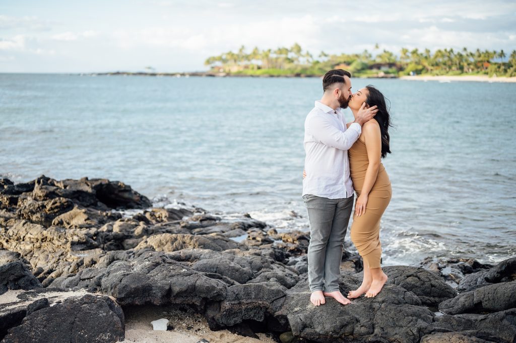 engagement photo of the couple kissing on the lava rocks