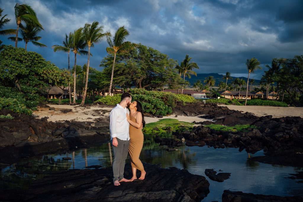 couple kissing on the lava rocks at a Hawaii beach