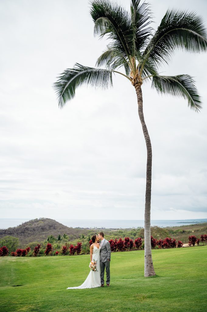 couple kissing under the coconut tree during their Hawaii wedding
