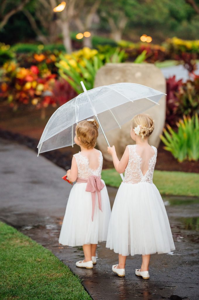 the flower girls under the umbrella by wedding photographer