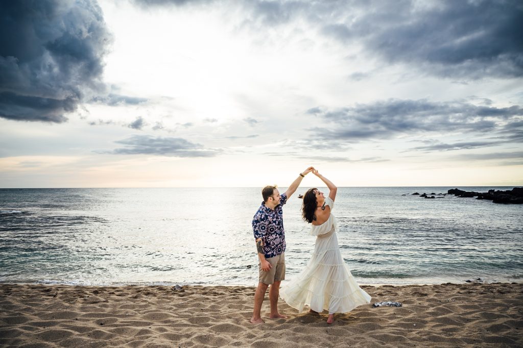 couple twirling at Kukio beach by Hawaii photographer