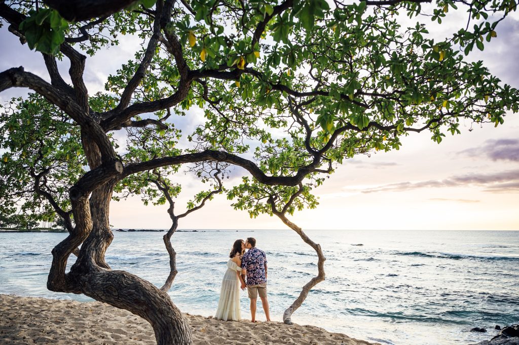 couple kissing at the beach during their Hawaii engagement session 