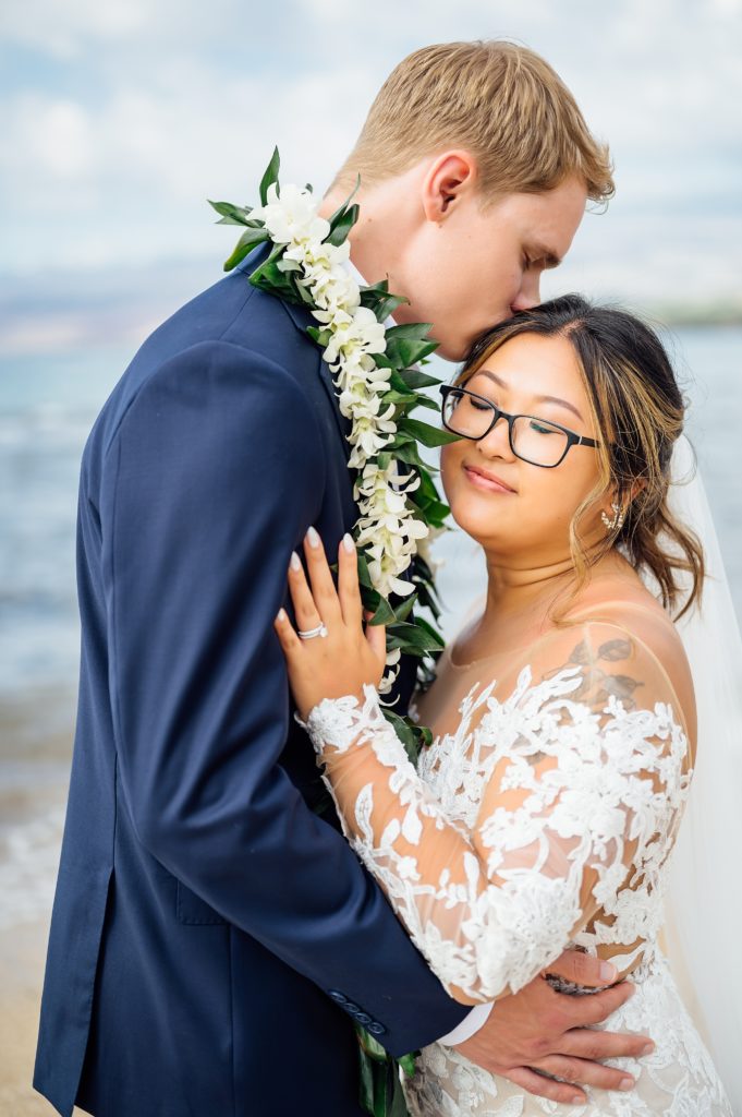 groom kissing bride's head during their Big Island wedding