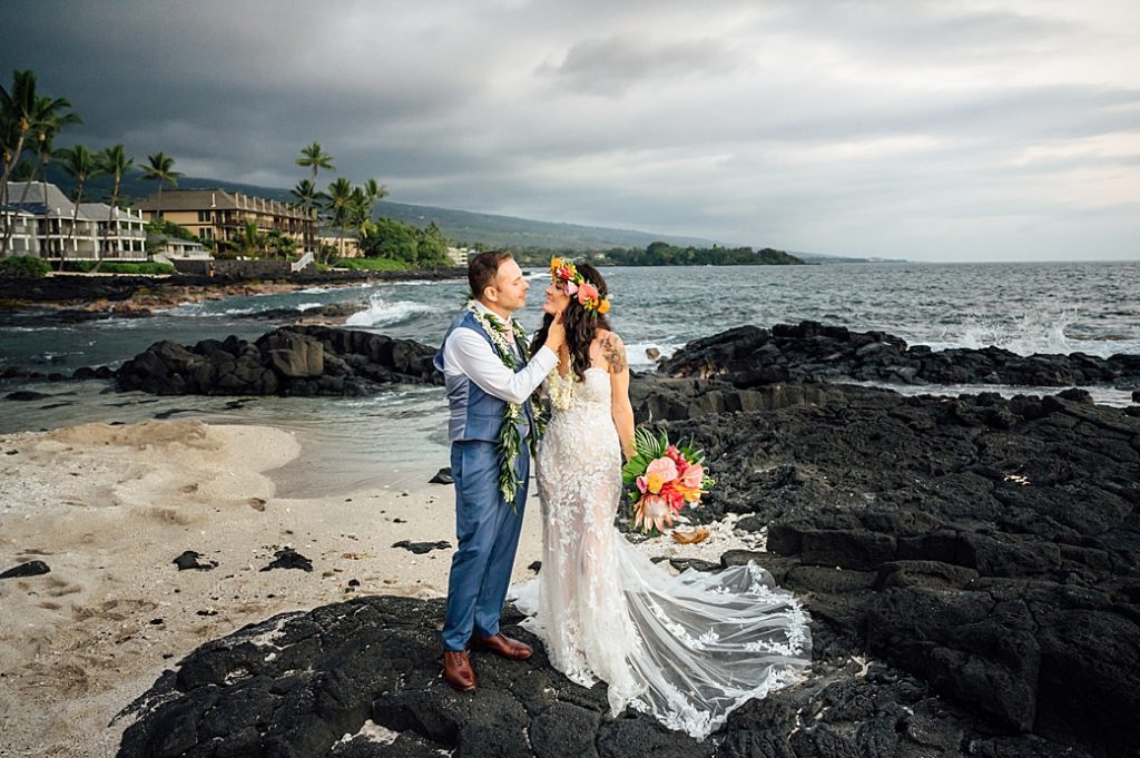 newlyweds on standing the lava rocks after their Hawaii wedding