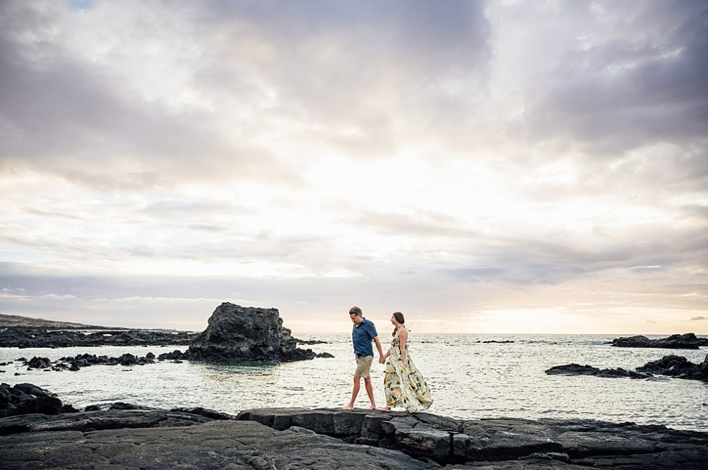 engagement photo of the couple walking on the lava rocks