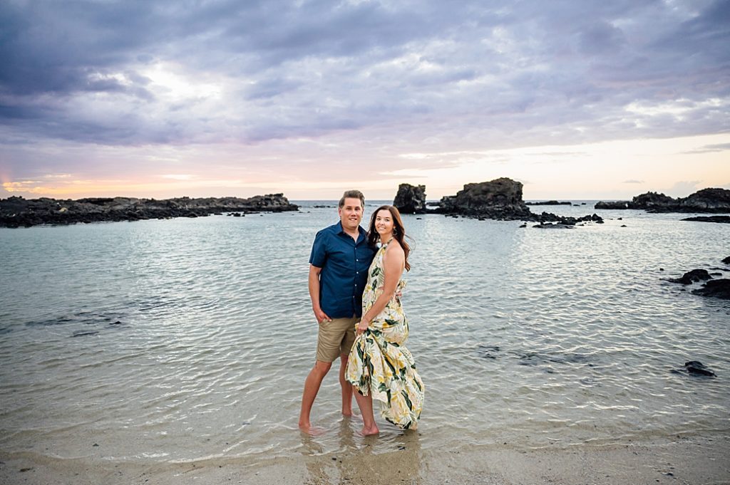 engagement photo of couple dipping their toes in the water