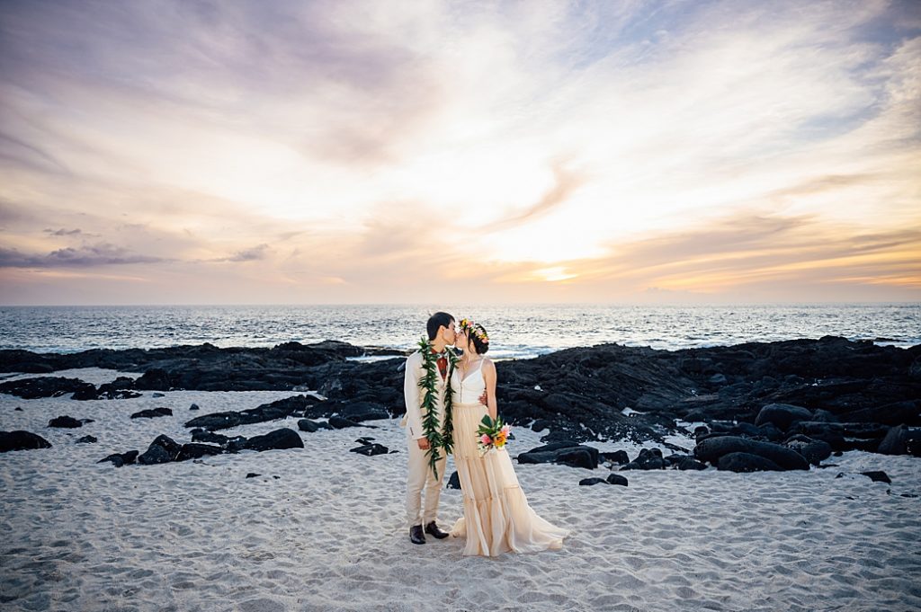 bride and groom kiss during sunset by Kona wedding photographer