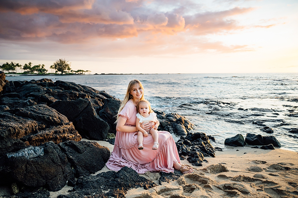 mom and daughter on the lava rocks during sunset